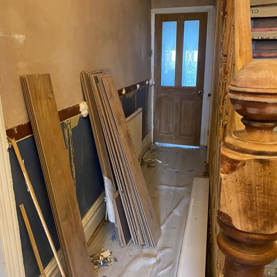 Hallway before panelling with flooring stacked ready to fit