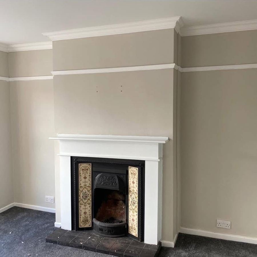 Living room with restored fireplace, picture rail and fresh neutral paint