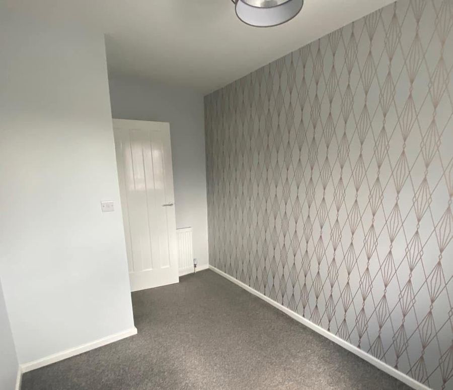 Bedroom with patterned wallpaper before repaint