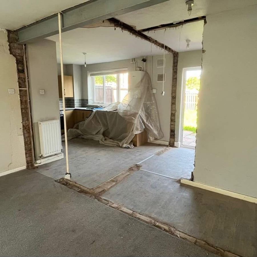 Kitchen and living room before wall removal, mid-demolition